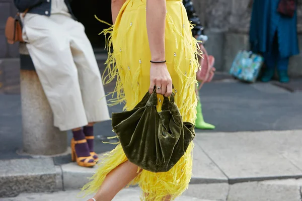 Mujer con vestido amarillo con flecos de plumas y bolsa de terciopelo verde antes del desfile de moda Antonio Marras, Milan Fashion Week street style on septiembre 23, 2017 in Milan . — Foto de Stock