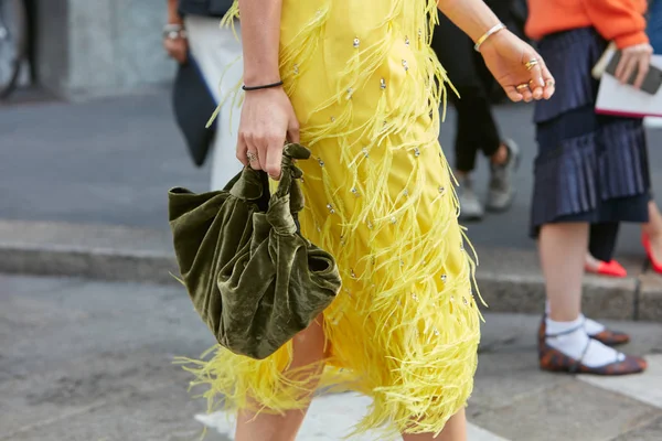 Kobieta spacerująca z żółtą sukienką z frędzlami i zieloną aksamitną torbą przed pokazem mody Antonio Marras, Milan Fashion Week street style 23 września 2017 w Mediolanie. — Zdjęcie stockowe
