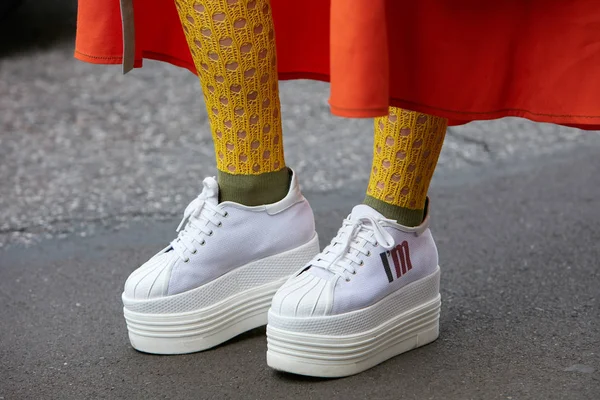 Kvinna med hög kil klack vita sneakers skor och orange kjol innan Antonio Marras modevisning, Milan Fashion Week street style den 23 september 2017 i Milano. — Stockfoto