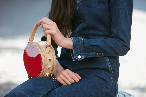 Blumarine moda defilesinden önce kırmızı ve bej renkli Salar deri çantalı ve kot pantolonlu kadın, Milan Moda Haftası tarzı 23 Eylül 2017 'de Milano' da.