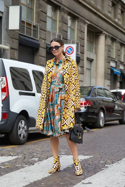 23 Eylül 2017 'de Milan' da, Antonio Marras moda defilesinden önce sarı renkli ceketli ve renkli elbiseli bir kadın..