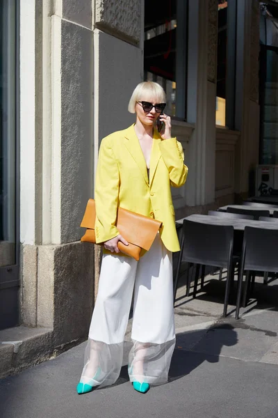 Kobieta w żółtej kurtce i turkusowych butach przed pokazem mody Blumarine, Milan Fashion Week street style 23 września 2017 w Mediolanie. — Zdjęcie stockowe