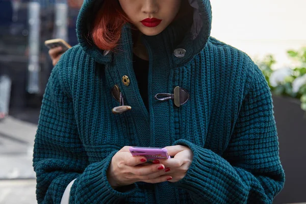 Mujer con chaqueta de lana verde oscuro con capucha mirando el teléfono inteligente antes del desfile de moda Blumarine, Milan Fashion Week street style on septiembre 23, 2017 in Milan . — Foto de Stock