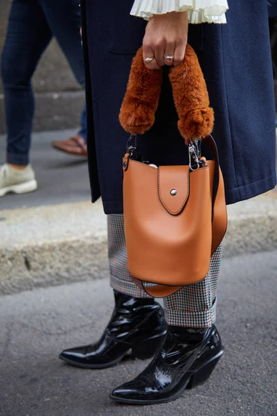 Kvinna med brunt läder väska med pälshandtag och svart lackläder stövlar före Ermanno Scervino modevisning, Milan Fashion Week street style den 23 september 2017 i Milano. — Stockfoto