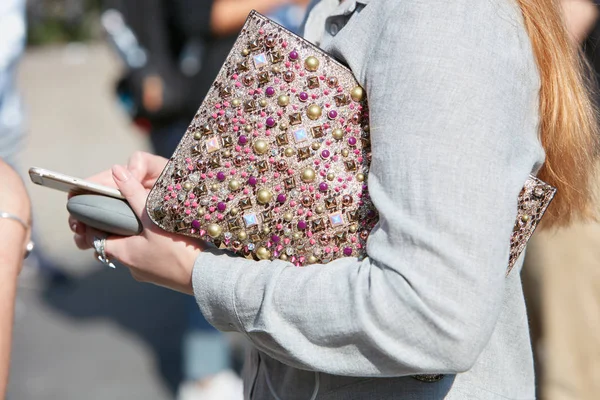 Nő táska arany szegecsekkel dekoráció és gyöngyök nézi telefon előtt Trussardi divatbemutató, Milánó Fashion Week utcai stílus szeptember 24, 2017 a Milan. — Stock Fotó