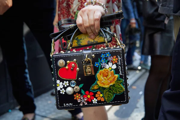 Vrouw met zwarte Dolce en Gabbana tas met bloemdecoratie voor Dolce en Gabbana modeshow, Milaan Fashion Week straatstijl op 24 september 2017 in Milaan. — Stockfoto