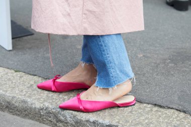 Woman with pink satin Mango shoes and torn blue jeans trousers before fashion Albino Teodoro show, Milan Fashion Week street style on February 21, 2018 in Milan.