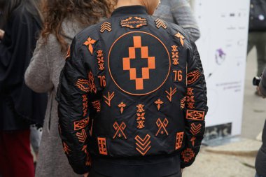 Moda Albino Teodoro gösterisi öncesi siyah ve turuncu desenli Marcel Burlon ceketli adam, Milano Moda Haftası sokak stili 21 Şubat 2018'de Milano'da.