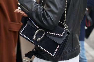 Gucci moda defilesinden önce siyah Gucci çantalı ve siyah deri ceketli kadın, Milan Moda Haftası 21 Şubat 2018 'de Milano' da.