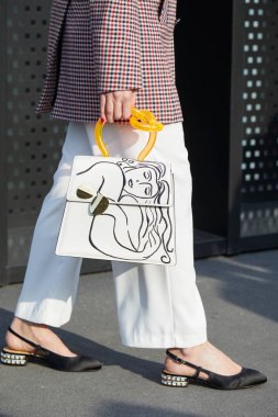 Kadın tasarımı ve turuncu saplı beyaz çantalı kadın Gucci moda defilesinden önce yürüyor, Milan Moda Haftası 21 Şubat 2018 'de Milano' da.