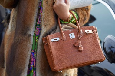 Hermes kahverengi timsah derisi çantalı ve kahverengi kürklü kadın Gucci moda şovundan önce, Milan Moda Haftası 21 Şubat 2018 'de Milano' da.