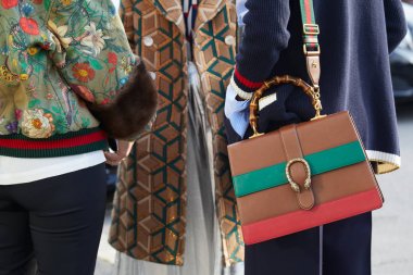 Gucci moda defilesinden önce Gucci deri çantalı, kahverengi, yeşil ve kırmızı deri ceketli kadınlar, Milan Moda Haftası tarzı 21 Şubat 2018 'de Milano' da.