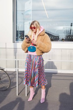 Gucci moda defilesinden önce bej kürklü, mavi kadife Gucci kesesi ve çizgili metalik eteği olan kadın, Milan Moda Haftası 21 Şubat 2018 'de Milano' da.