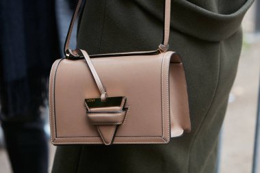 MILAN - FEBRUARY 22: Woman with brown leather Loewe bag and dark