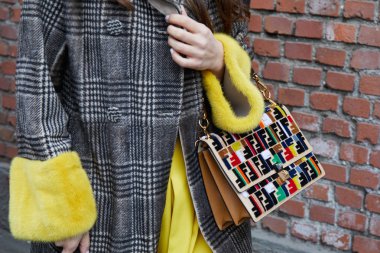 MILAN - FEBRUARY 22: Woman with coat with yellow fur cuffs and b
