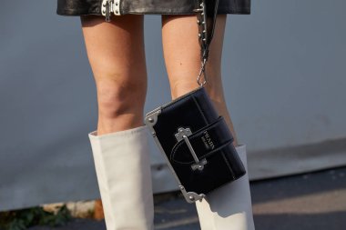 D2 moda defilesinden önce siyah deri Prada çantalı ve beyaz çizmeli kadın, Milan Moda Haftası tarzı 14 Ocak 2018 'de Milano' da.