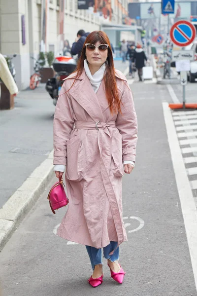 Žena s růžovým pláštěm a taškou kráčející před módní přehlídkou Albino Teodoro, Milan módní týden ulice styl 21. února 2018 v Miláně. — Stock fotografie