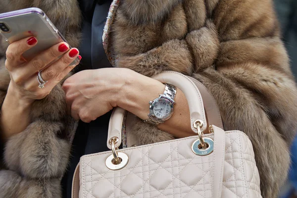 Woman with Chopard watch and Christian Dior bag looking at smartphone before fashion Albino Teodoro show, Milan Fashion Week street style 21 лютого 2018 у Мілані. — стокове фото