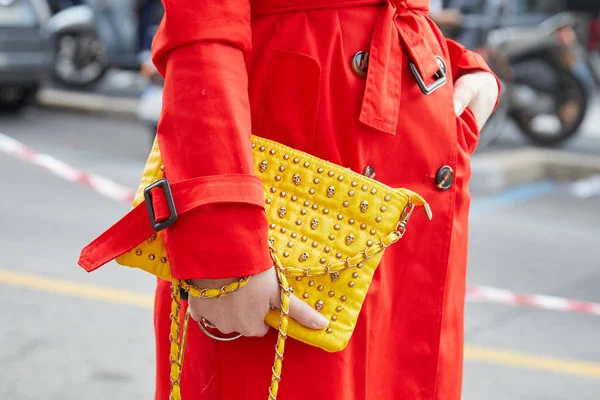 Kvinna med gul läderväska med små skallar och röd trenchcoat före mode Albino Teodoro show, Milan Fashion Week street style den 21 februari 2018 i Milano. — Stockfoto