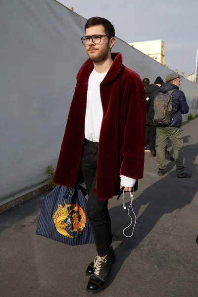 Человек в темно-красной шубе и сумке с золотым драконом перед показом Dsquared 2, уличный стиль Миланской недели моды 14 января 2018 года в Милане . — стоковое фото