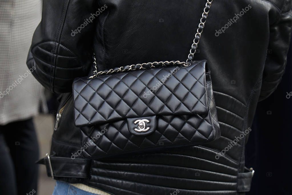 MILAN - FEBRUARY 21: Woman with black Chanel leather bag and jacket before fashion Albino Teodoro show, Milan Fashion Week street style on February 21, 2018 in Milan.