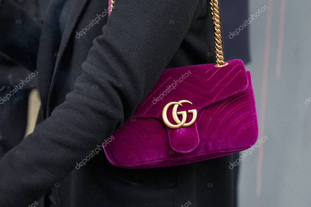 MILAN - FEBRUARY 21: Woman with purple velvet Gucci bag with golden logo and chain before fashion Albino Teodoro show, Milan Fashion Week street style on February 21, 2018 in Milan.