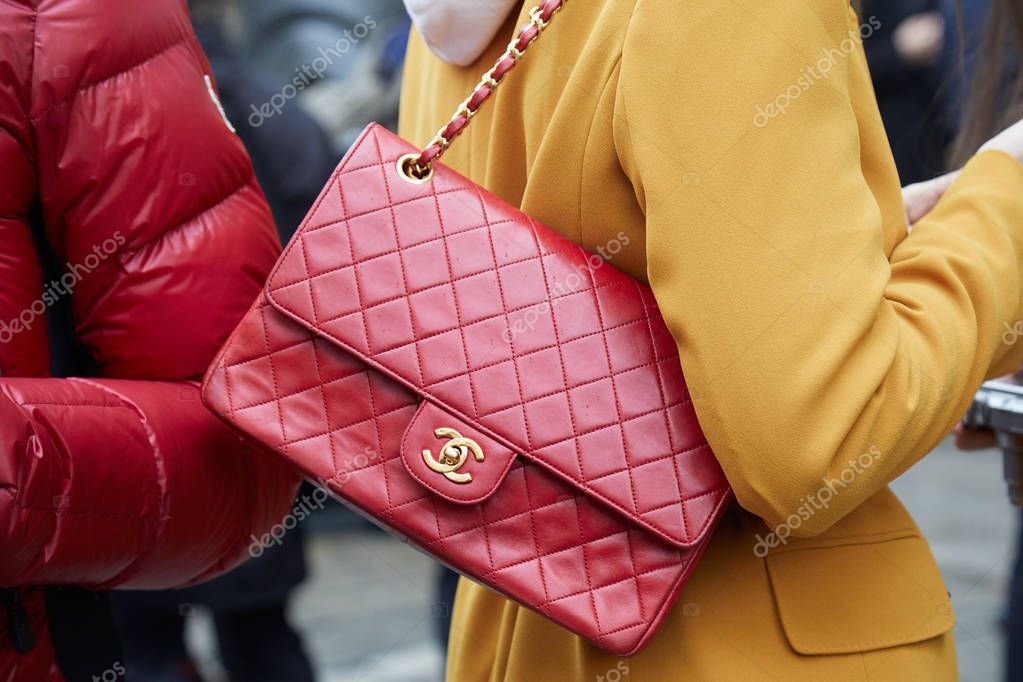 MILAN - FEBRUARY 22: Woman with red Chanel leather bag and yellow jacket before Max Mara fashion show, Milan Fashion Week street style on February 22, 2018 in Milan.