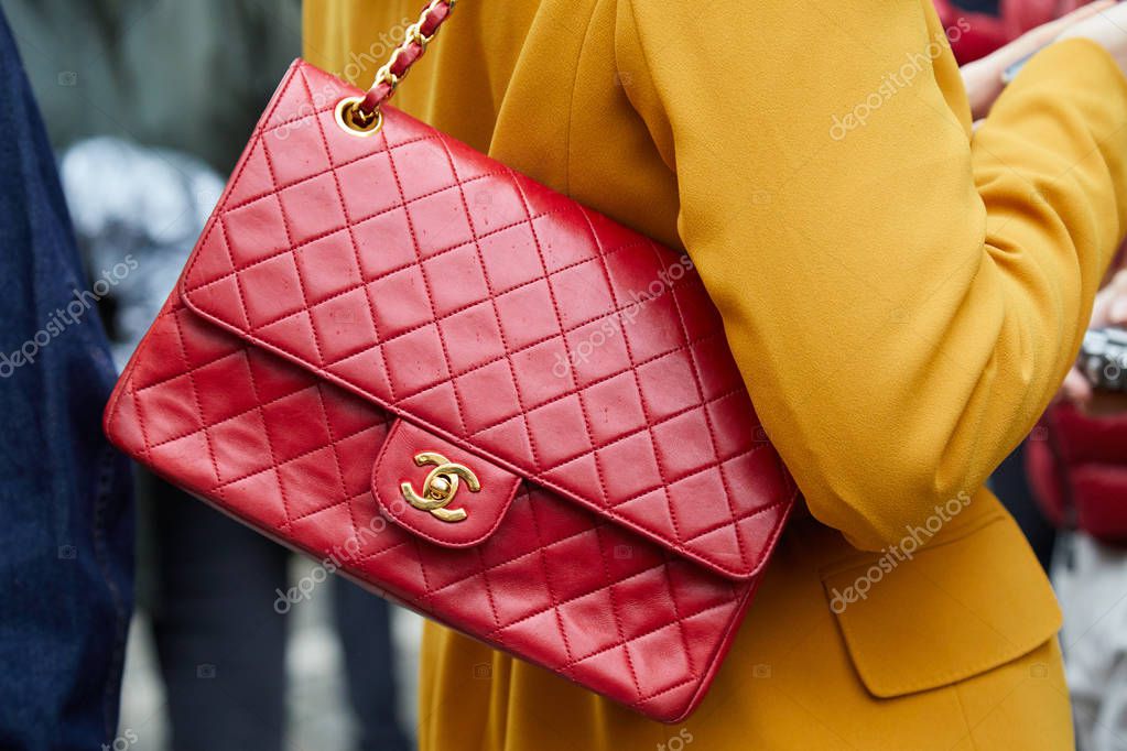 MILAN - FEBRUARY 22: Woman with red Chanel leather bag and yellow jacket before Max Mara fashion show, Milan Fashion Week street style on February 22, 2018 in Milan.