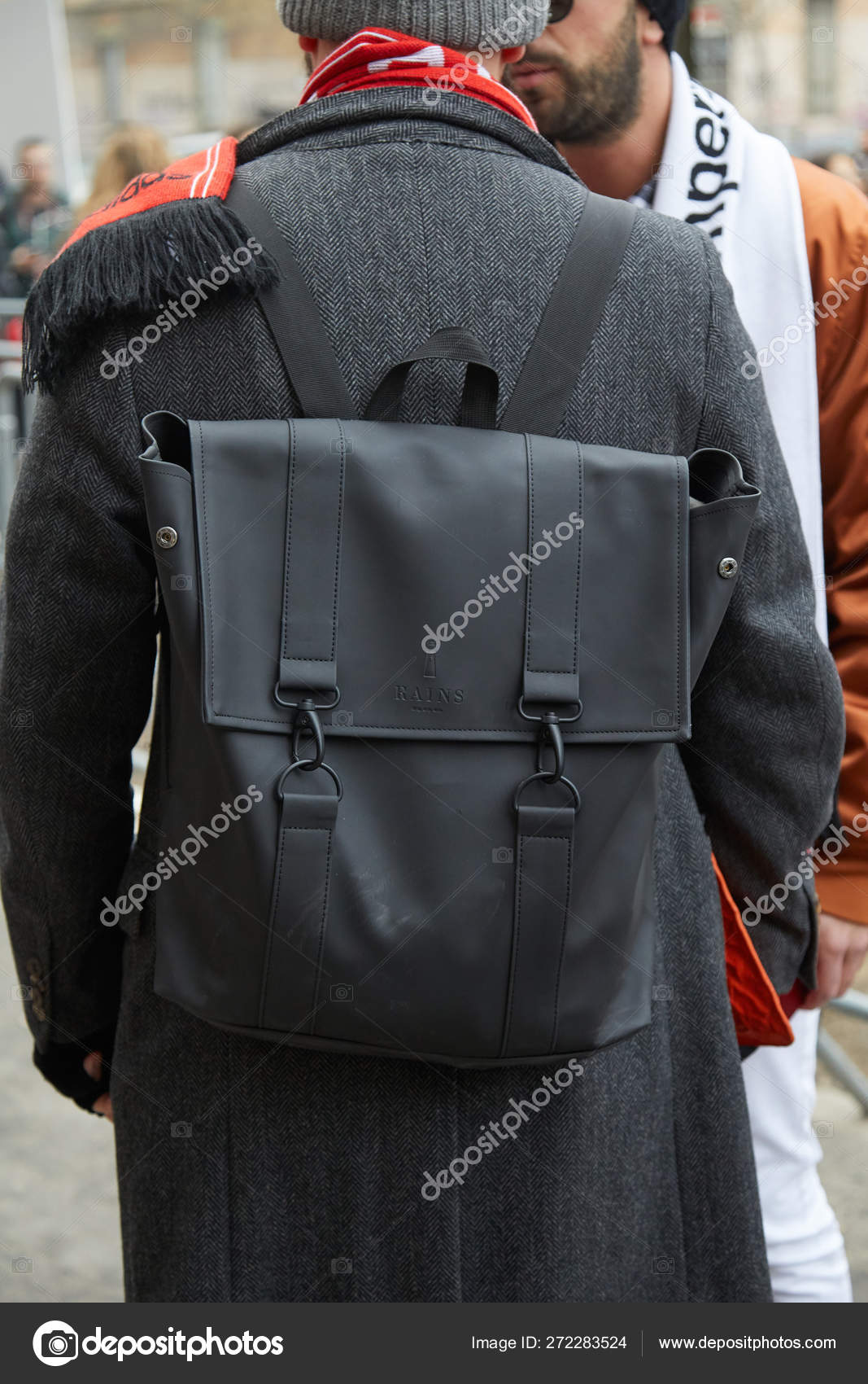 Homme avec sac à dos pluie en cuir noir et manteau gris avant le
