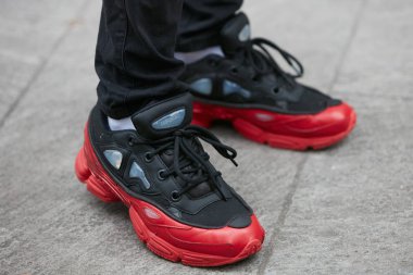 Giorgio Armani defilesinden önce siyah ve kırmızı Raf Simons spor ayakkabılı adam, Milano Moda Haftası sokak stili 15 Ocak 2018'de Milano'da.