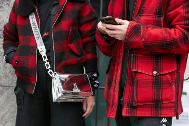 Giorgio Armani moda defilesinden önce kırmızı ve siyah kareli ceketli kadın ve erkek. Milan Moda Haftası tarzı 15 Ocak 2018 'de Milano' da.