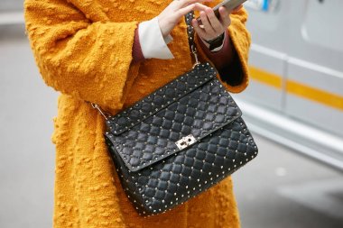 Giorgio Armani defilesinden önce siyah deri çantalı ve sarı ceketli kadın, Milan Moda Haftası 15 Ocak 2018 'de Milano' da.
