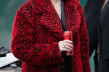 Giorgio Armani defilesinden önce kırmızı ve beyaz kürklü kadın ve Coca Cola kutusu, Milan Moda Haftası sokak stili 15 Ocak 2018, Milano.