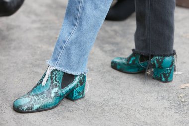 Giorgio Armani moda defilesinden önce yeşil yılan derisi ayakkabılı ve kot pantolonlu kadın, Milan Moda Haftası 15 Ocak 2018 'de Milano' da.