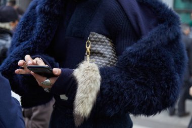 Giorgio Armani defilesinden önce akıllı telefona bakan mavi kürkmanlı ve Faure Le Page çantalı adam, Milano Moda Haftası sokak stili 15 Ocak 2018'de Milano'da.