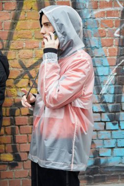 Fendi defilesi öncesi şeffaf yağmurluklu adam, Milano Moda Haftası sokak stili 15 Ocak 2018'de Milano'da.