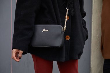 Siyah deri çantalı ve kırmızı pantolonlu kadın moda defilesinden önce 15 Ocak 2018 'de Milano Moda Haftası tarzında.