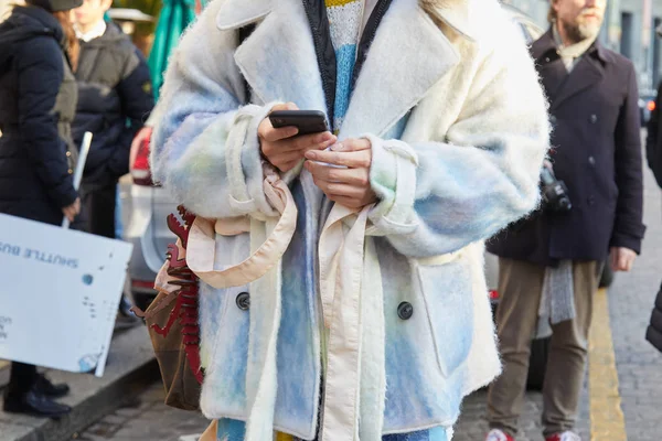 2018年1月14日、ミラノで開催されたDaksファッションショー、ミラノファッションウィークストリートスタイルの前に電話を見ている白と水色のコートを着た男性. — ストック写真