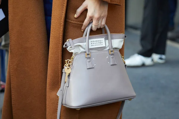 Frau mit grauer Ledertasche mit goldenem Schlüssel und beigem Mantel vor daks Modenschau, Mailänder Modewoche Streetstyle am 14. Januar 2018 in Mailand. — Stockfoto