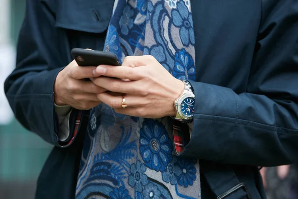 Человек с часами Breitling, печатающий на смартфоне перед показом мод Джорджио Армани, уличный стиль Миланской недели моды 15 января 2018 года в Милане . — стоковое фото