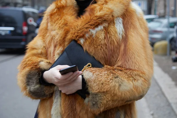 Kvinna med röd räv päls som tittar på smartphone innan Fendi modevisning, Milan Fashion Week street style den 15 januari 2018 i Milano. — Stockfoto