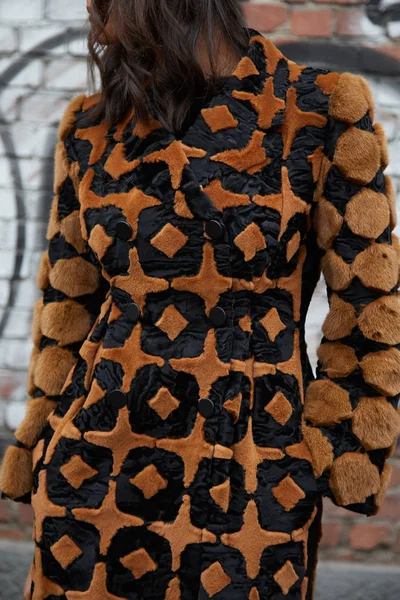 Mujer con abrigo de piel decorado negro y marrón antes del desfile de moda Fendi, Milan Fashion Week street style el 15 de enero de 2018 en Milán . —  Fotos de Stock