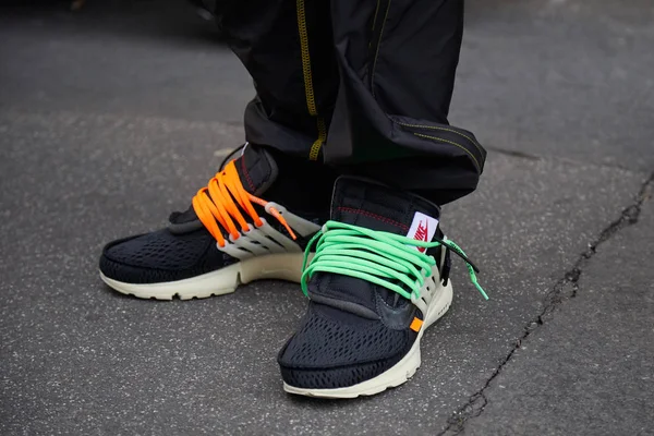 Temsil defilesinden önce turuncu ve yeşil ayakkabı bağcıklı siyah Nike ayakkabılı adam, Milano Moda Haftası sokak stili 15 Ocak 2018'de Milano'da. — Stok fotoğraf