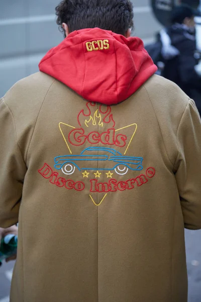 Temsil defilesinden önce Gcds bej paltolu ve kırmızı kapüşonlu adam, Milano Moda Haftası sokak stili 15 Ocak 2018'de Milano'da.
