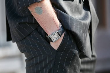 Emporio Armani defilesinden önce siyah timsah deri kayışı ve çizgili takım elbiseli Cartier saatli adam, Milano Moda Haftası sokak stili 