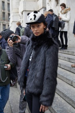 Frankie Morello defilesinden önce siyah kürk manto ve panda şapkalı top model, Milano Moda Haftası sokak stili 