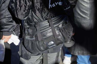 Siyah derili Adam Emporio Armani defilesinden önce Kuzey Yüz Supreme kese, Milano Moda Haftası sokak stili 