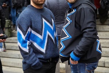 Frankie Morello defilesinden önce siyah, beyaz ve mavi geometrik tasarım kazak ve ceketli erkekler, Milano Moda Haftası sokak stili 