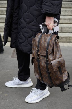 Man with brown Louis Vuitton backpack and black padded jacket before Frankie Morello fashion show, Milan Fashion Week street style  clipart