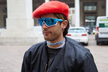 Man with red hat and blue Oakley sunglasses before Frankie Morello fashion show, Milan Fashion Week street style  clipart